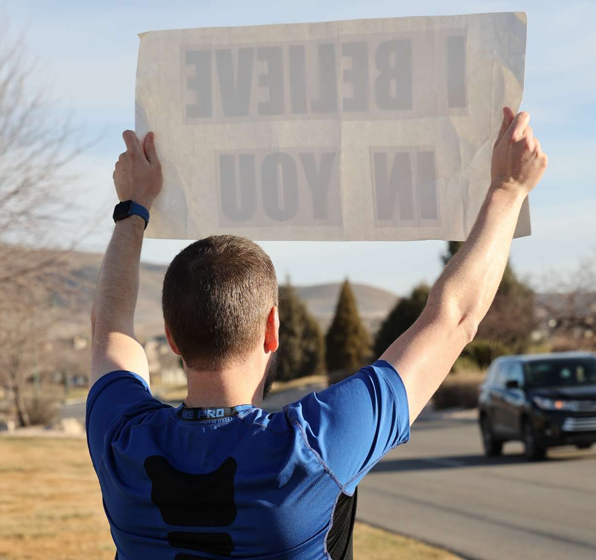 Ben Lyne holds a signs saying "I believe in you," for passersby in Eagle Mountain. Lyne has organized the motivational mile event, intended to create a mile-long chain of similar messages set to happen June 6.