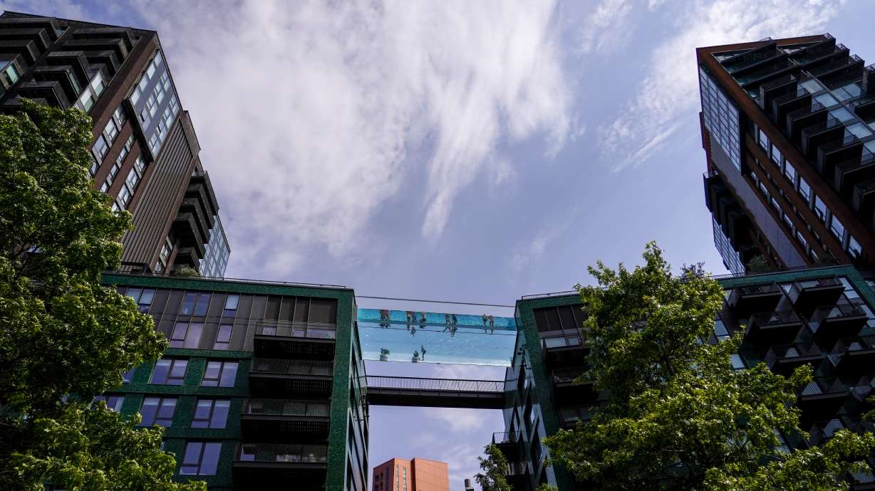 People swim in the elevated pool, called Sky Pool, in London, Monday. Britain shattered its record for highest temperature ever registered amid a heat wave that has seared swaths of Europe.