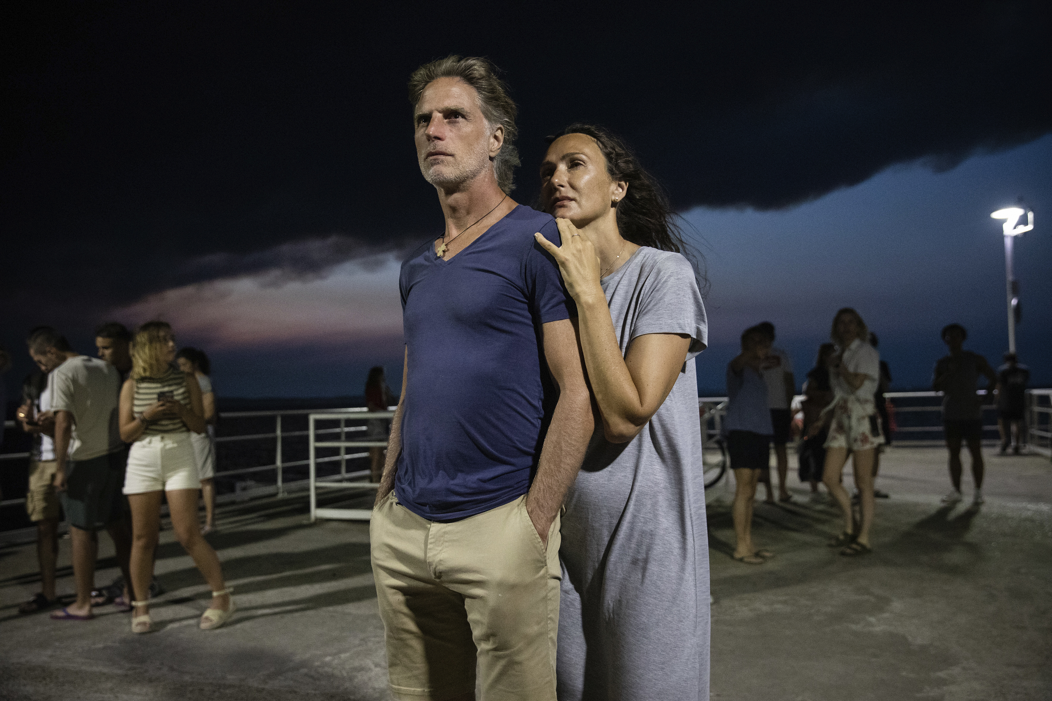 A couple stands on the Le Moulleau pier in Arcachon, southwestern France, late Monday, as a large cloud of black smoke laden with ashes coming from a giant wildfire consuming the thousand-year-old forest bordering the Dune du Pilat fills the sky.