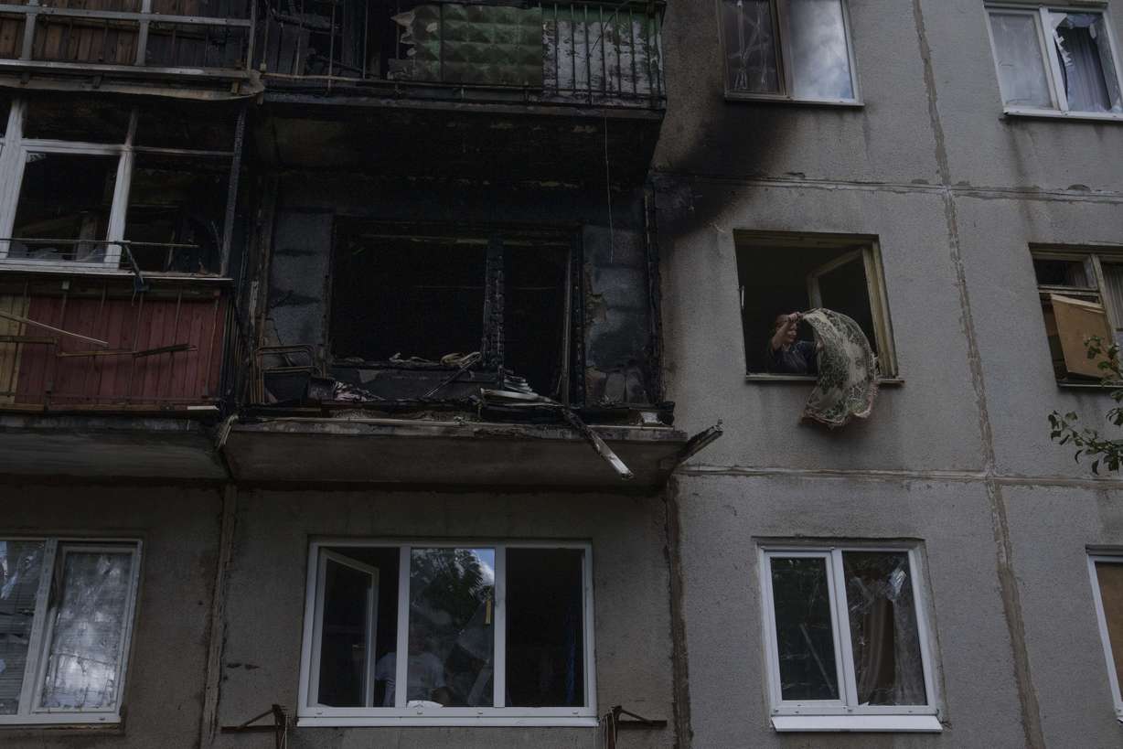 A woman salvages what she can from her damaged apartment, after a rocket hit her five-story residential building, in Kramatorsk, eastern Ukraine, Tuesday.