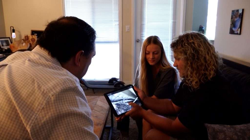 Avery and Sam Shrader show KSL-TV’s Matt Gephardt video they captured after a carport at their apartment complex collapsed and damaged their motorcycle.