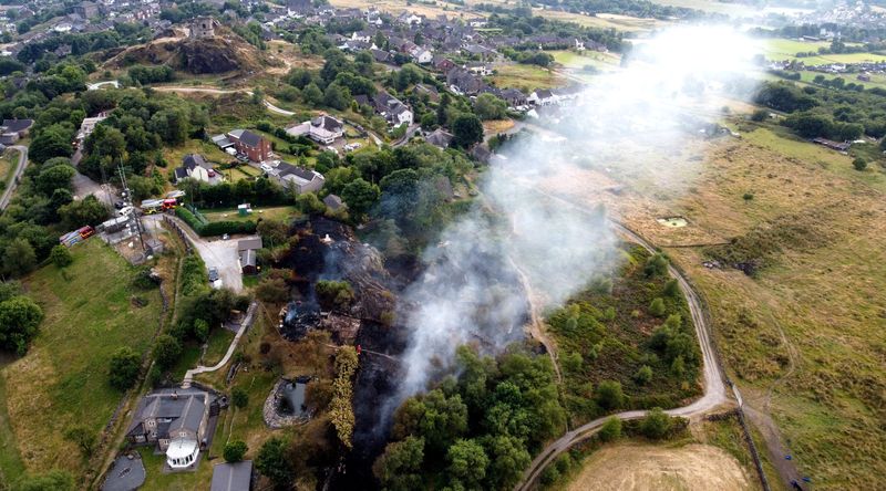 Firefighters tackle a grass fire during the heatwave in Mow Cop, Staffordshire, Britain, on Tuesday.