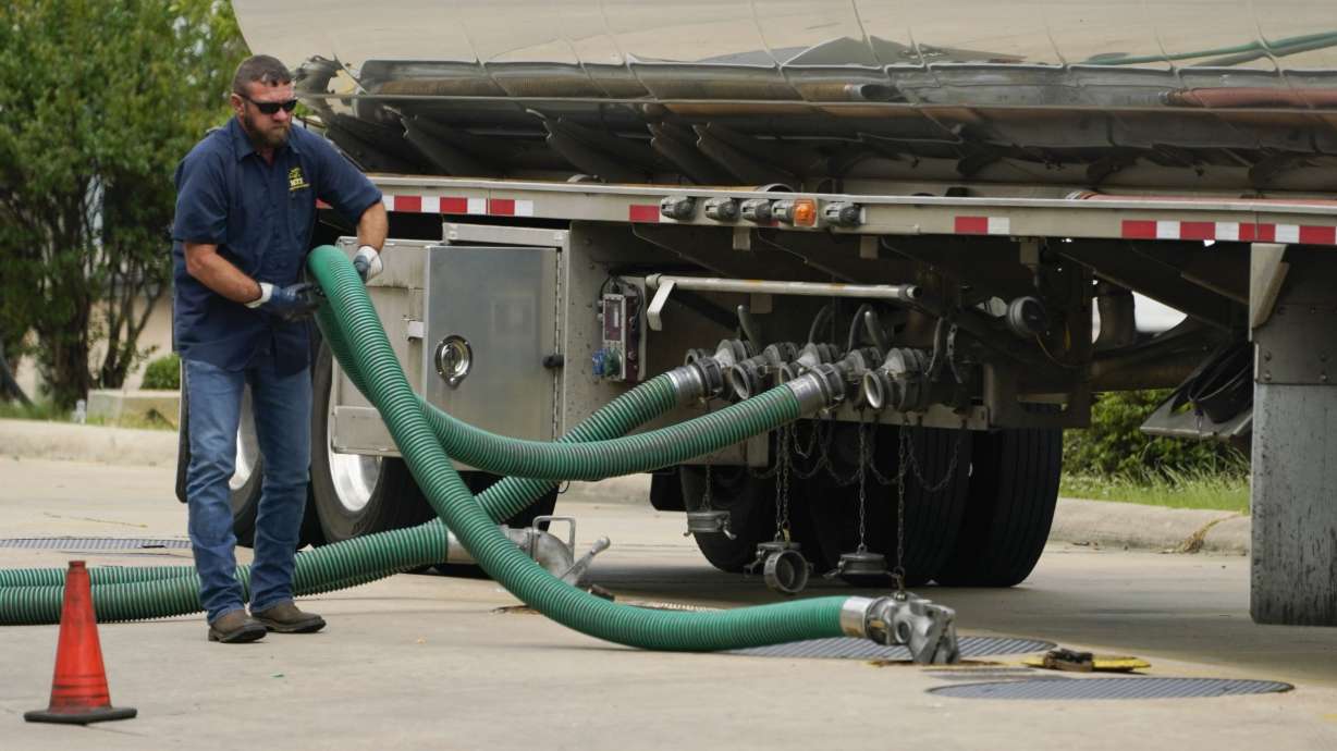 A gas tank driver adjusts his hose hookup to an underground tank on May 24 in Jackson, Miss. High diesel prices are driving up the cost of most goods, from groceries to Amazon orders and furniture, as nearly everything that is delivered, whether by truck, rail or ship, uses diesel fuel.
