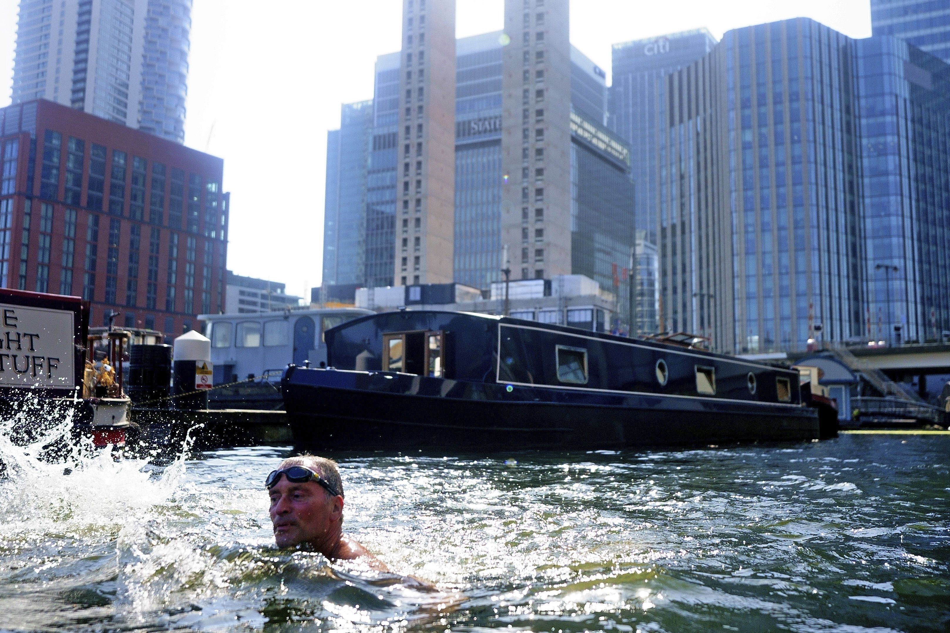 A swimmer in water in the Canary Wharf docklands in east London, on Tuesday. Britain shattered its record for highest temperature ever registered amid a heat wave that has seized swaths of Europe. The national weather forecaster predicted it would get hotter still Tuesday in a country ill prepared for such extremes.