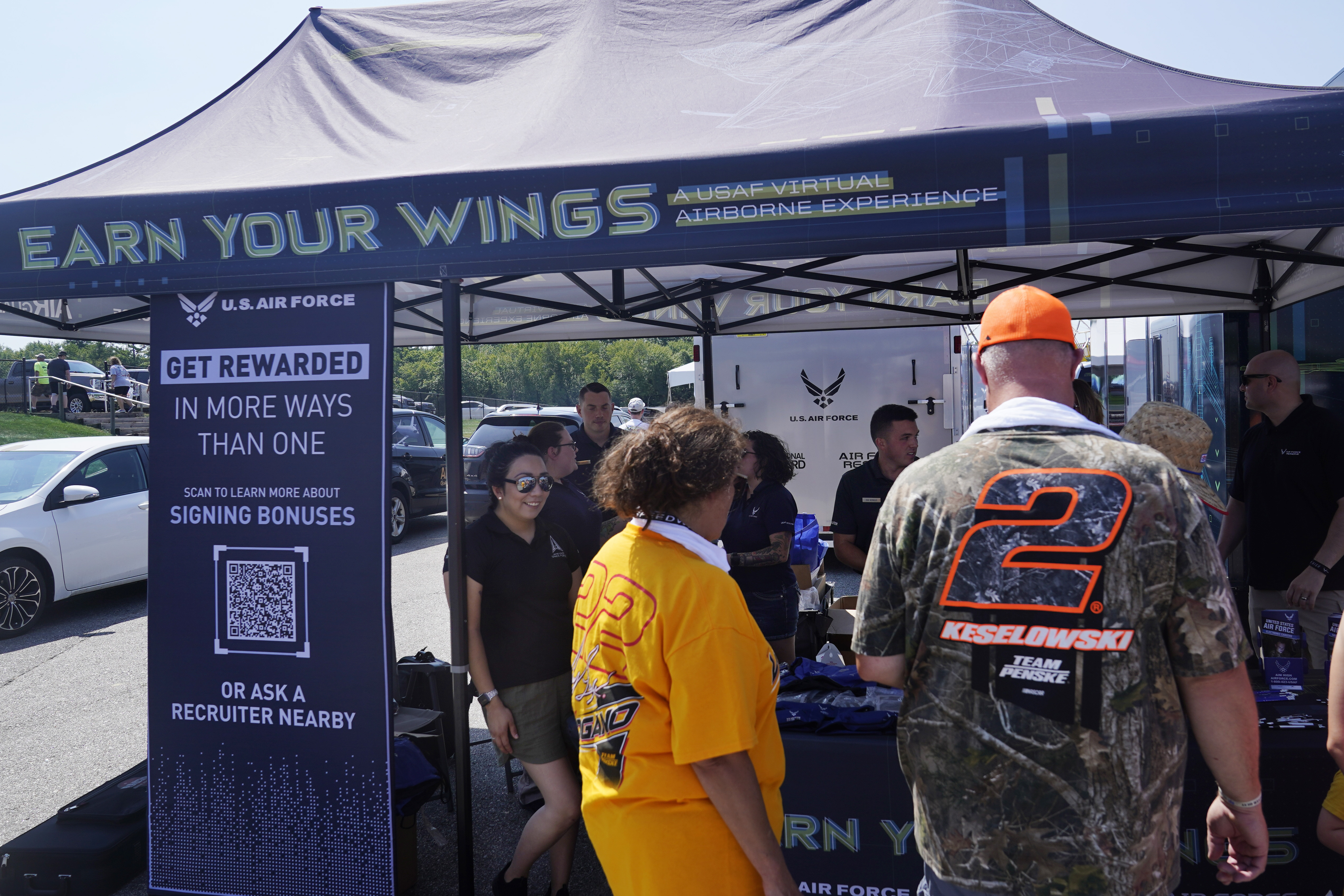 Racing fans stop at the U.S. Air Force recruiting tent prior to a NASCAR race at the New Hampshire Motor Speedway, Sunday, July 17, in Loudon, N.H. Recruiters are offering bigger bonuses and other incentives to those who sign up. And they are seizing on the boost that Hollywood may offer – such as the buzz over "Top Gun."