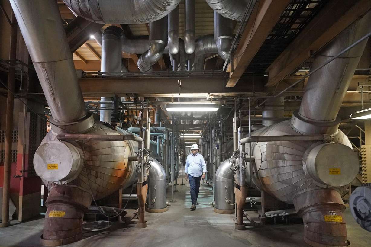 Intermountain Power Agency spokesperson John Ward walks through a coal power plant on June 22 in Delta. Developers in rural Utah who want to create big underground caverns to store hydrogen fuel won a $504 million loan guarantee this spring. They plan to convert the site of the 40-year-old coal plant to cleanly made hydrogen by 2045.