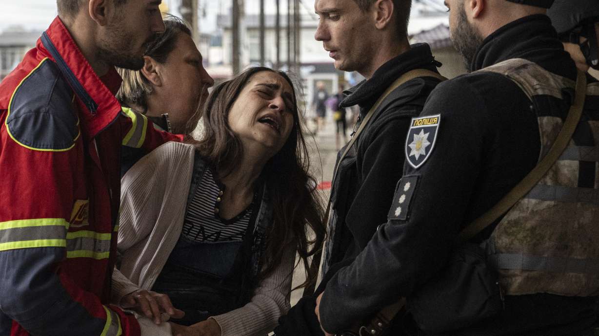 Sabina, centre, cries after her husband Artem Pogorelets was killed by Russian shelling at Barabashovo market in Kharkiv, Ukraine, Thursday.