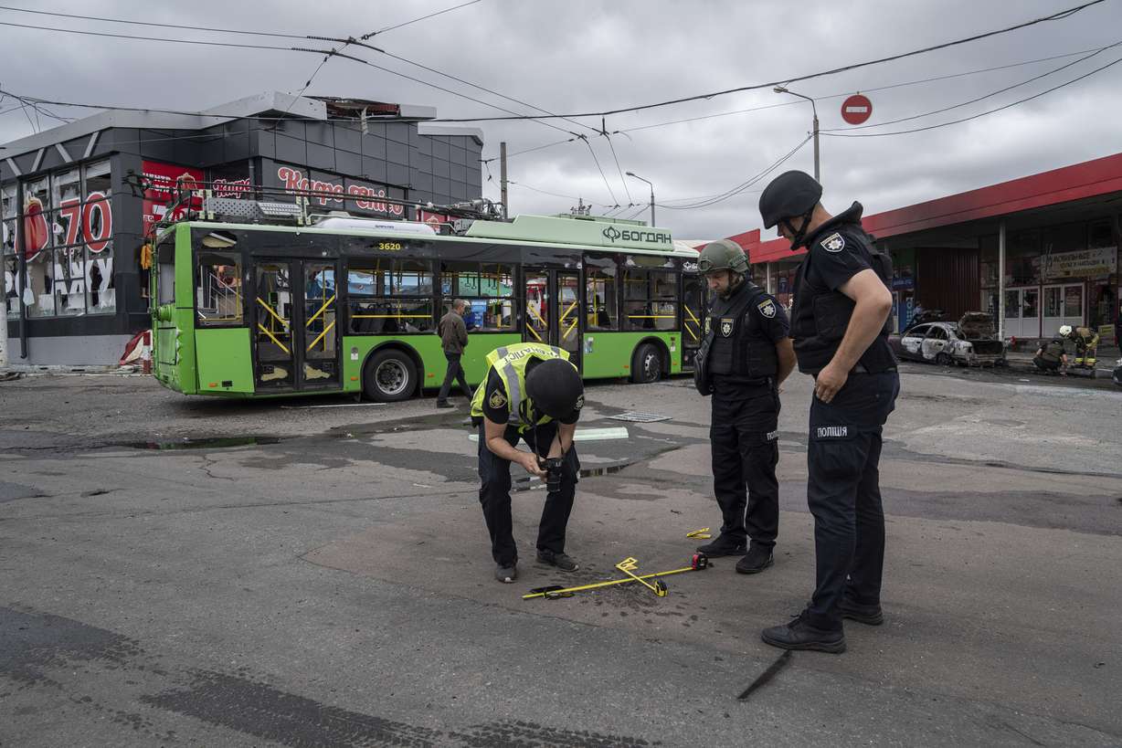 Des policiers enquêtent jeudi sur un petit cratère après un bombardement russe sur le marché de Barabashovo à Kharkiv, en Ukraine.