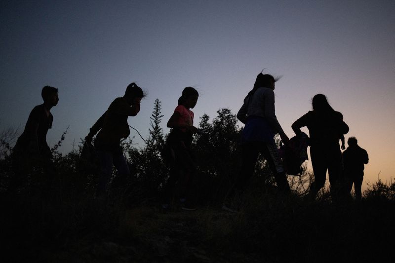 Migrants from Central and South America walk along a dirt trail after crossing the Rio Grande river into the United States from Mexico, in Roma, Texas, July 16. The U.S. Supreme Court on Thursday declined to reinstate President Joe Biden's policy shifting the focus of America's immigration enforcement toward public safety threats, handing a victory to Texas and Louisiana as they challenge a plan they call unlawful.