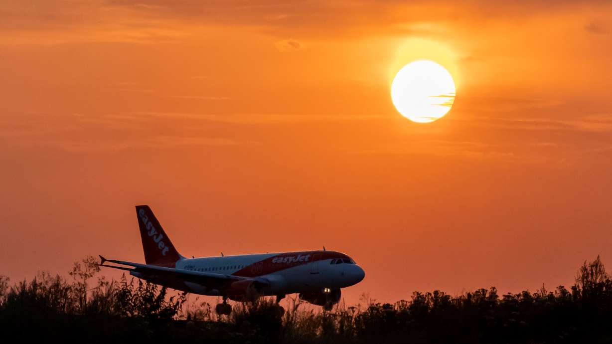 An Easy Jet plane lands during sunset at Luton Airport after a small section of the runway had lifted due to high temperatures on Monday, July 18.