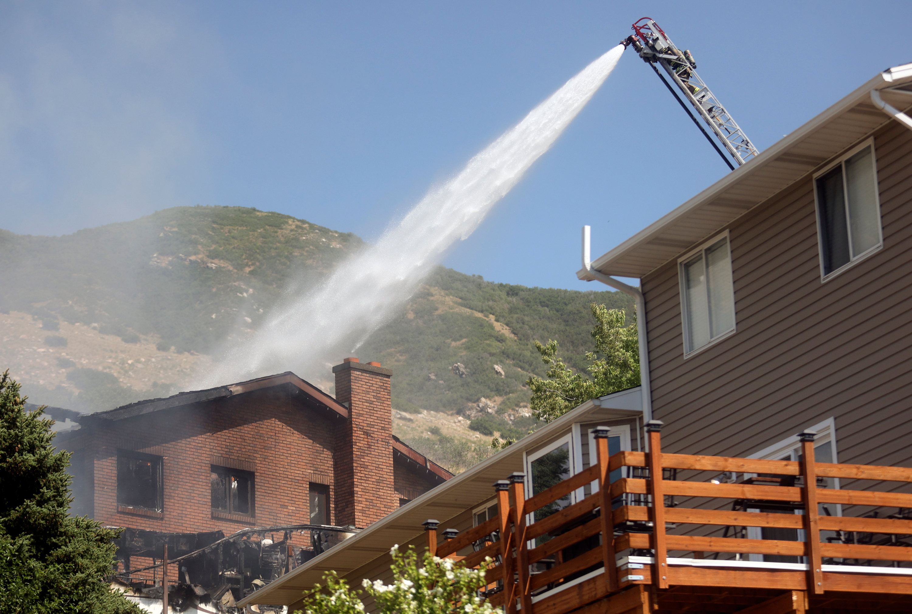 Emergency responders work at the scene of a house fire that was started by an armed intruder in Centerville on Thursday. Police pulled the intruder from the burning house and officers are being treated for smoke inhalation.