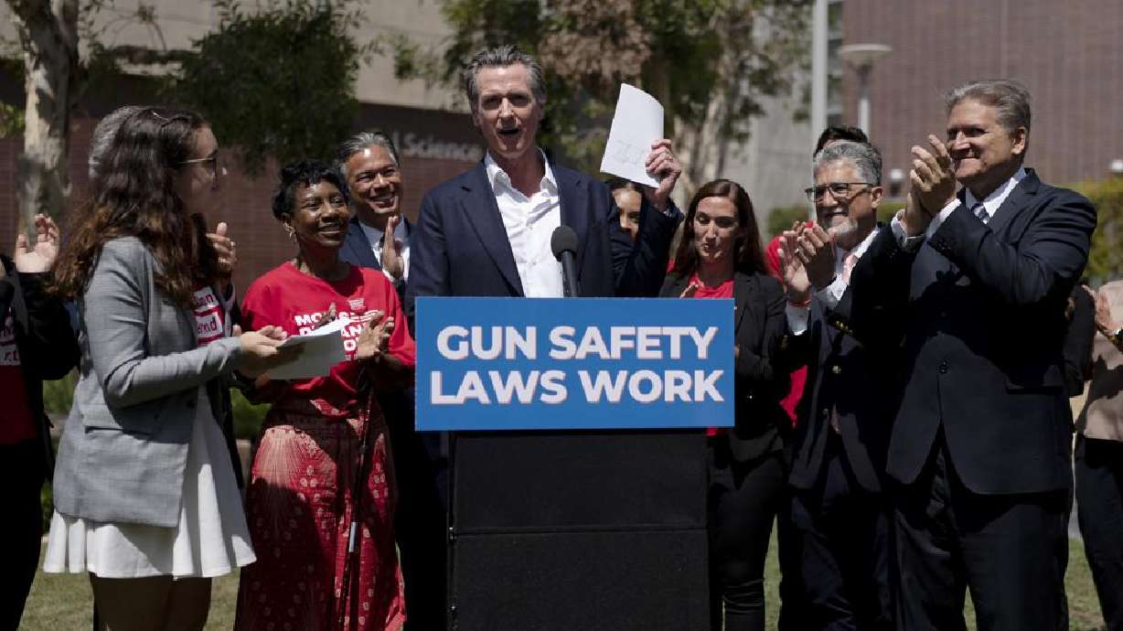 California Gov. Gavin Newsom, center, celebrates after singing a gun control law as he is surrounded by state officials including state Sen. Bob Hertzberg, right, state Sen. Anthony Portantino, second right, Attorney General Rob Bonta, third left, and gun violence survivors, Mia Tretta, and Arvis Jones, at Santa Monica College campus in Santa Monica, Calif., Friday.