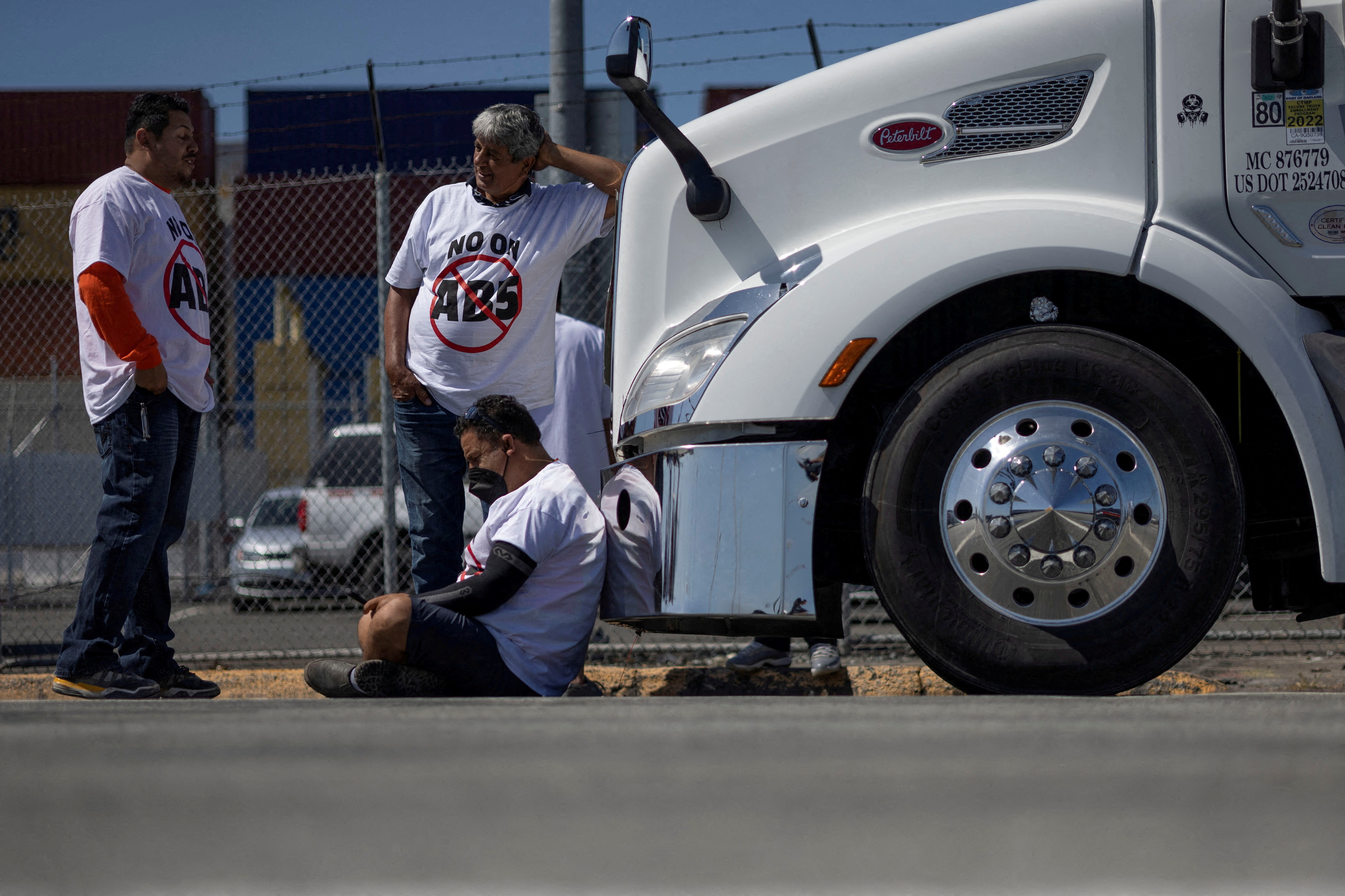 Independent truck drivers gather to delay the entry of trucks at a container terminal at the Port of Oakland, during a protest against California's law known as AB5, in Oakland, California, Thursday.   Independent truckers protesting California's new "gig worker" law blockaded California's No. 3 seaport for the third-straight day on Friday.