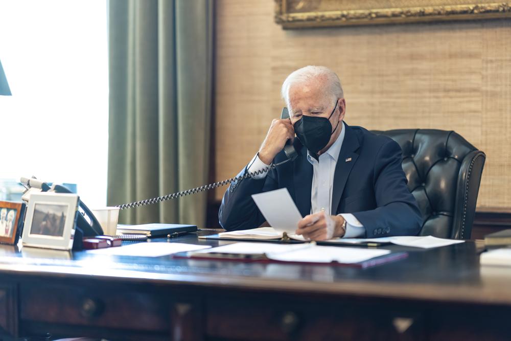 President Joe Biden talks on the phone with his national security team from the Treaty Room in the residence of the White House in Washington, Friday. Biden's physician says the president's COVID-19 symptoms have improved after a full day of treatment with the anti-viral drug Paxlovid and Tylenol. 