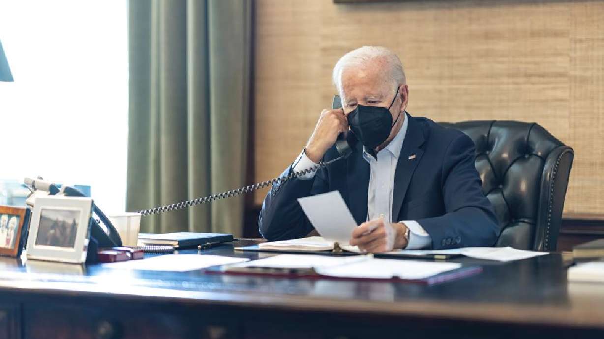 President Joe Biden talks on the phone with his national security team from the Treaty Room in the residence of the White House in Washington, Friday. Biden's physician says the president's COVID-19 symptoms have improved after a full day of treatment with the anti-viral drug Paxlovid and Tylenol.