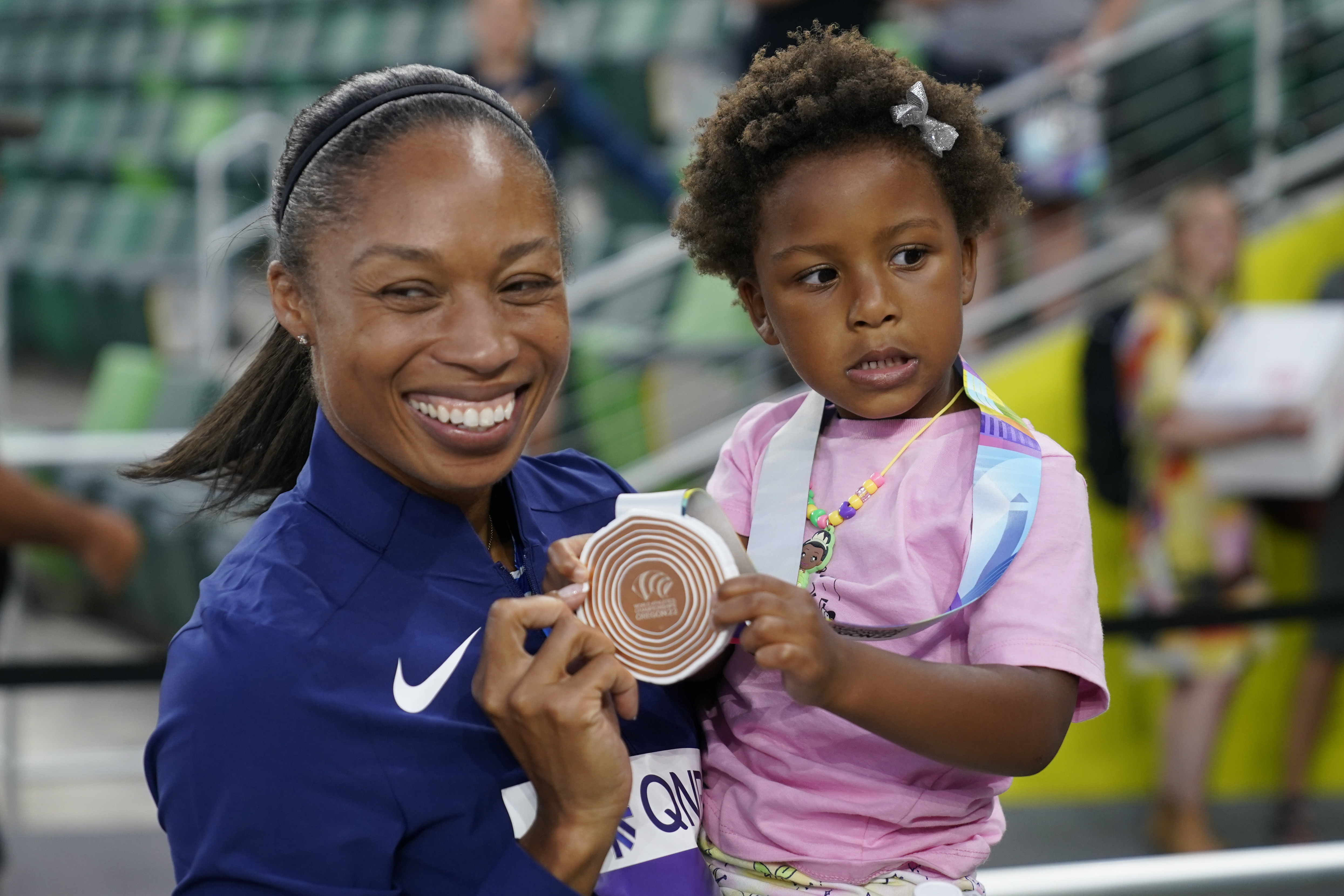 Allyson Felix, of the United States, gives her daughter Camryn her bronze medal after the 4x400-meter mixed relay final at the World Athletics Championships Friday, July 15, 2022, in Eugene, Ore.