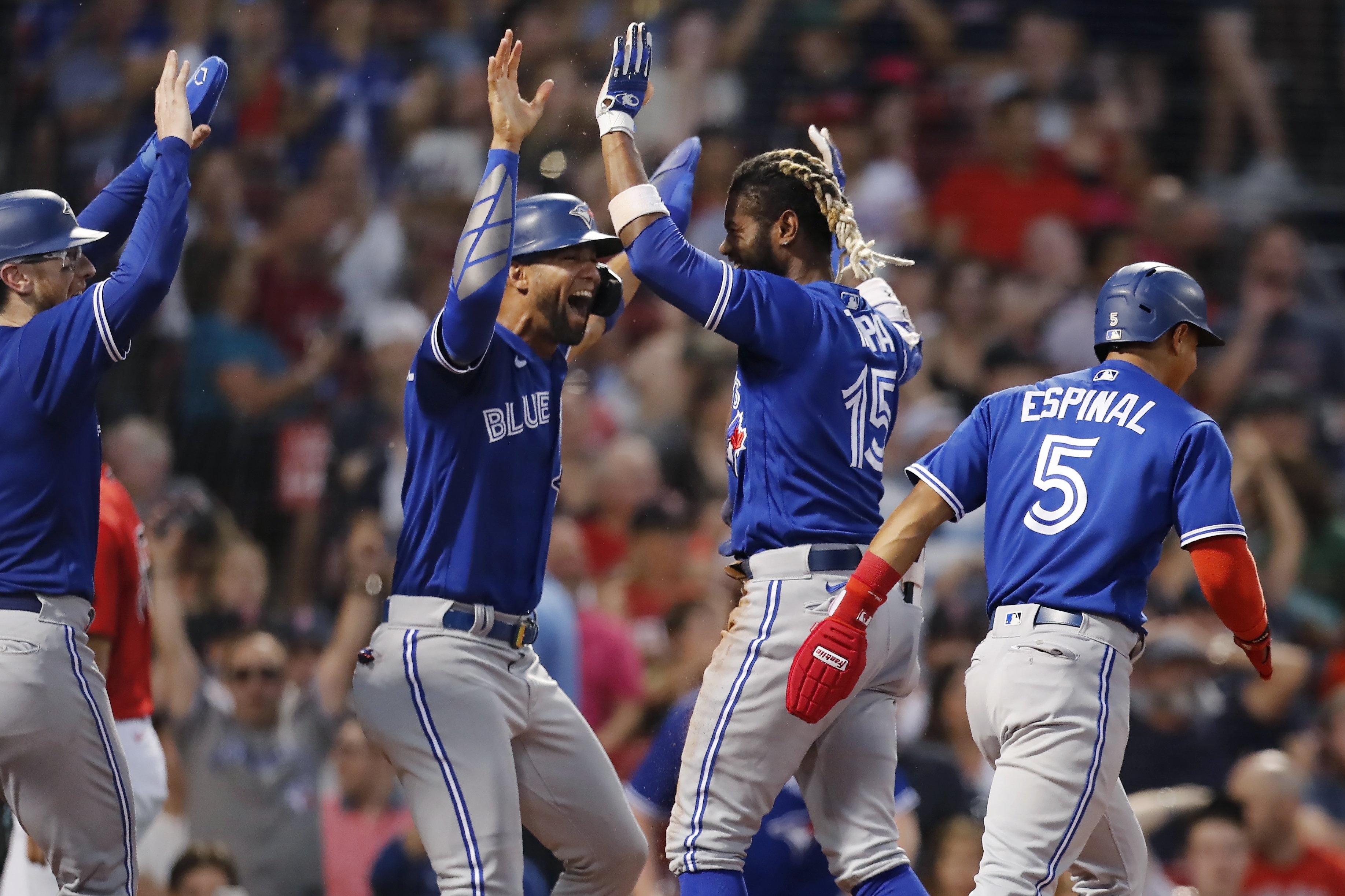 Toronto Blue Jays' Raimel Tapia (15) celebrates his inside-the-park grand slam that scored Lourdes Gurriel Jr., center left, Danny Jansen, left, and Santiago Espinal (5) during the third inning of the team's baseball game against the Boston Red Sox, Friday, July 22, 2022, in Boston. 