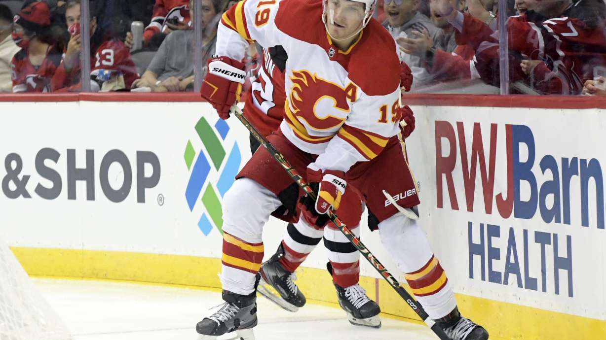 FILE - Calgary Flames left wing Matthew Tkachuk (19) looks to pass the puck during the second period of an NHL hockey game against the New Jersey Devils Tuesday, Oct. 26, 2021, in Newark, N.J. Matthew Tkachuk is being traded to the Florida Panthers, part of a blockbuster that sends Jonathan Huberdeau to the Calgary Flames in a swap of players who are each coming off the best season of their careers, a person with knowledge of the negotiations said Friday night, July 22, 2022.