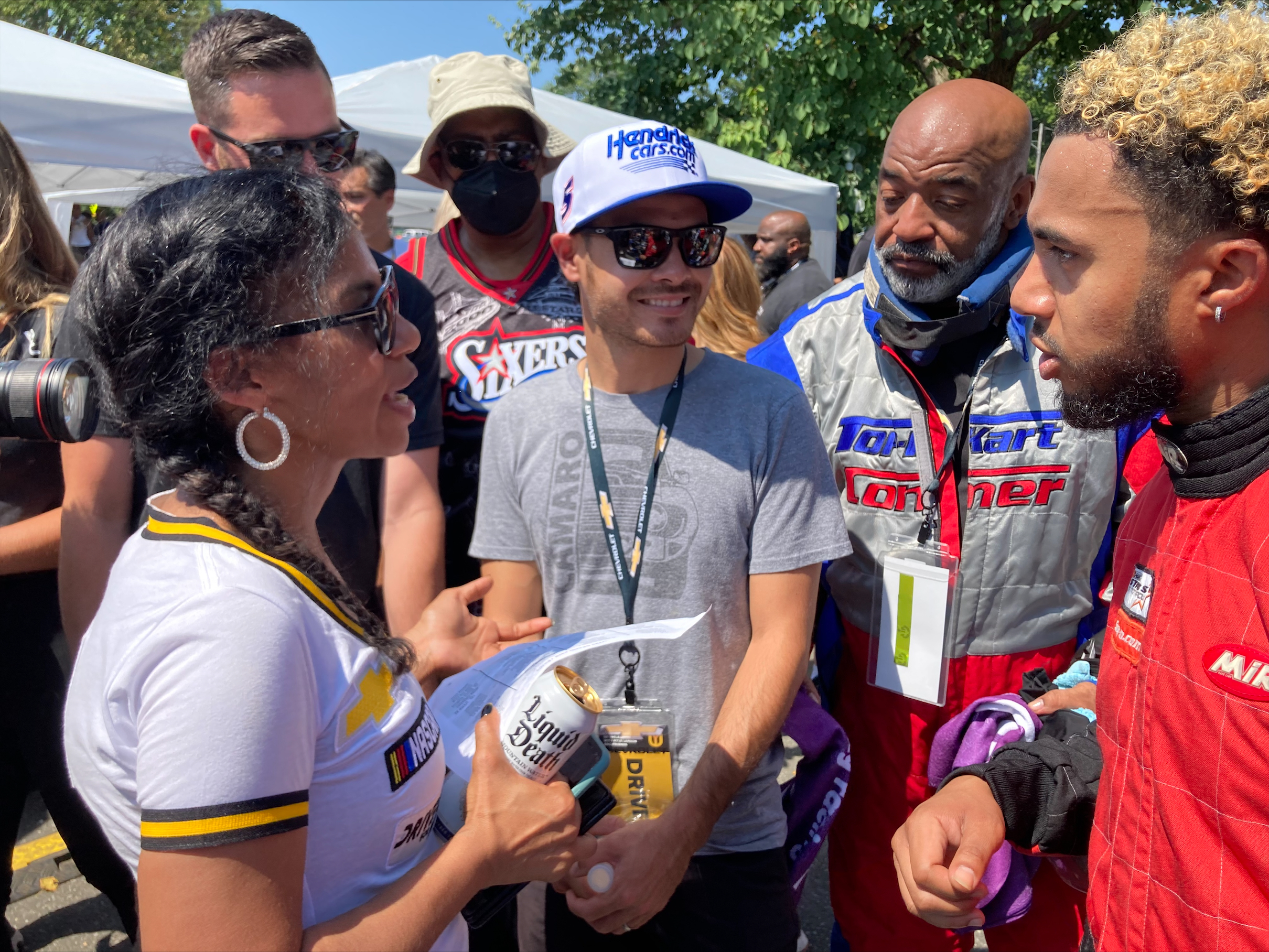NASCAR driver Kyle Larson, center, talks with members of the Urban Youth Racing School before the start of a race on the grounds of the Please Touch Museum in Philadelphia, Friday, July 22, 2022. 