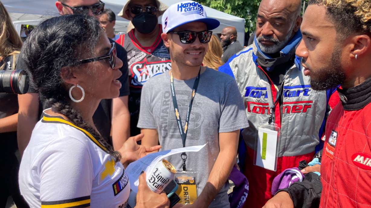 NASCAR driver Kyle Larson, center, talks with members of the Urban Youth Racing School before the start of a race on the grounds of the Please Touch Museum in Philadelphia, Friday, July 22, 2022.