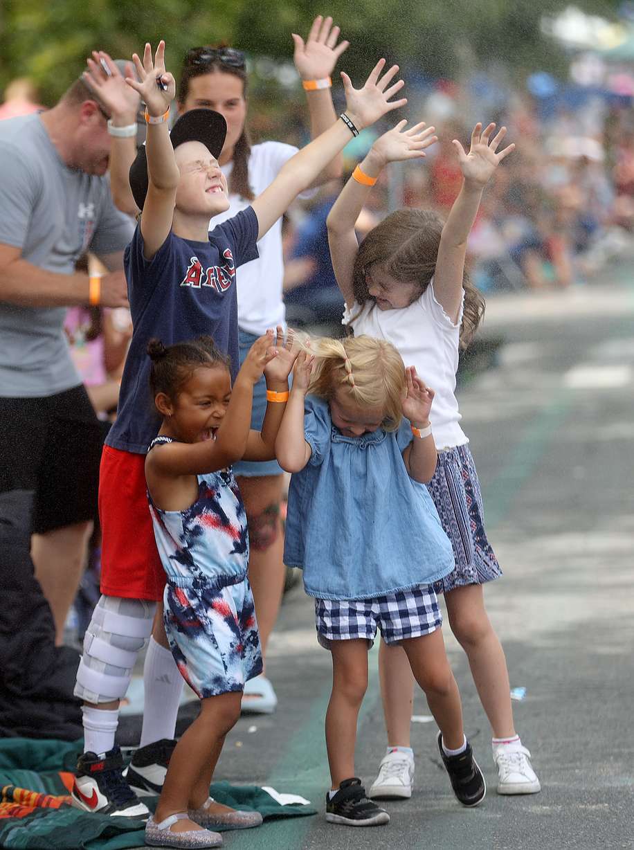 Nova Pendleton, Broc Pendleton, Sloan Senior and Sadie Owens react to being sprayed with water while watching the '47 Days Parade in Salt Lake City on Saturday.