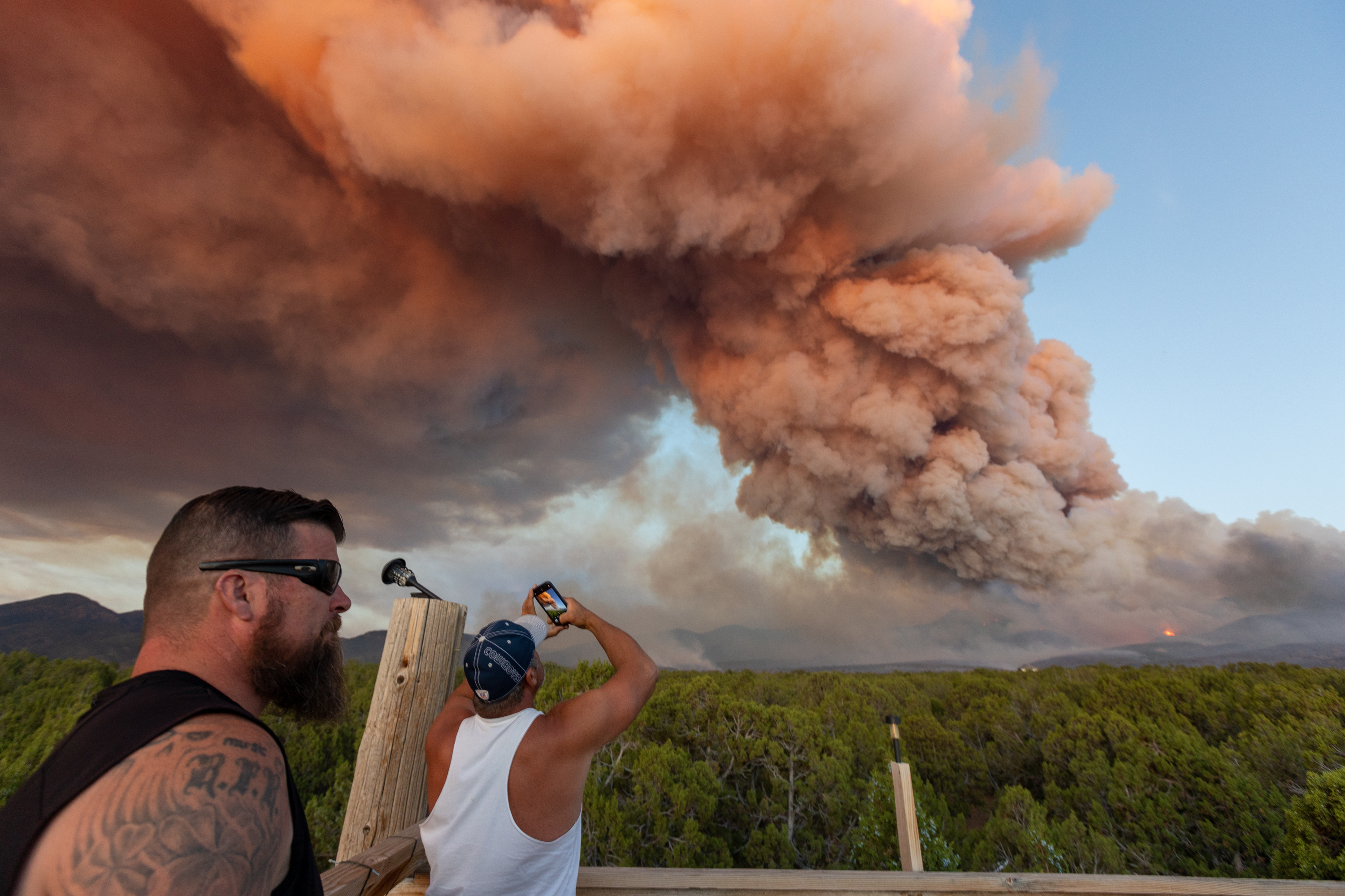 Flint Rogers stands next to Brendan Taylor, who films a fire with his phone, in Fillmore on July 8. The Halfway Hill Fire is still active, and as of Friday evening, was 70% contained and had burned 11,728 acres.
