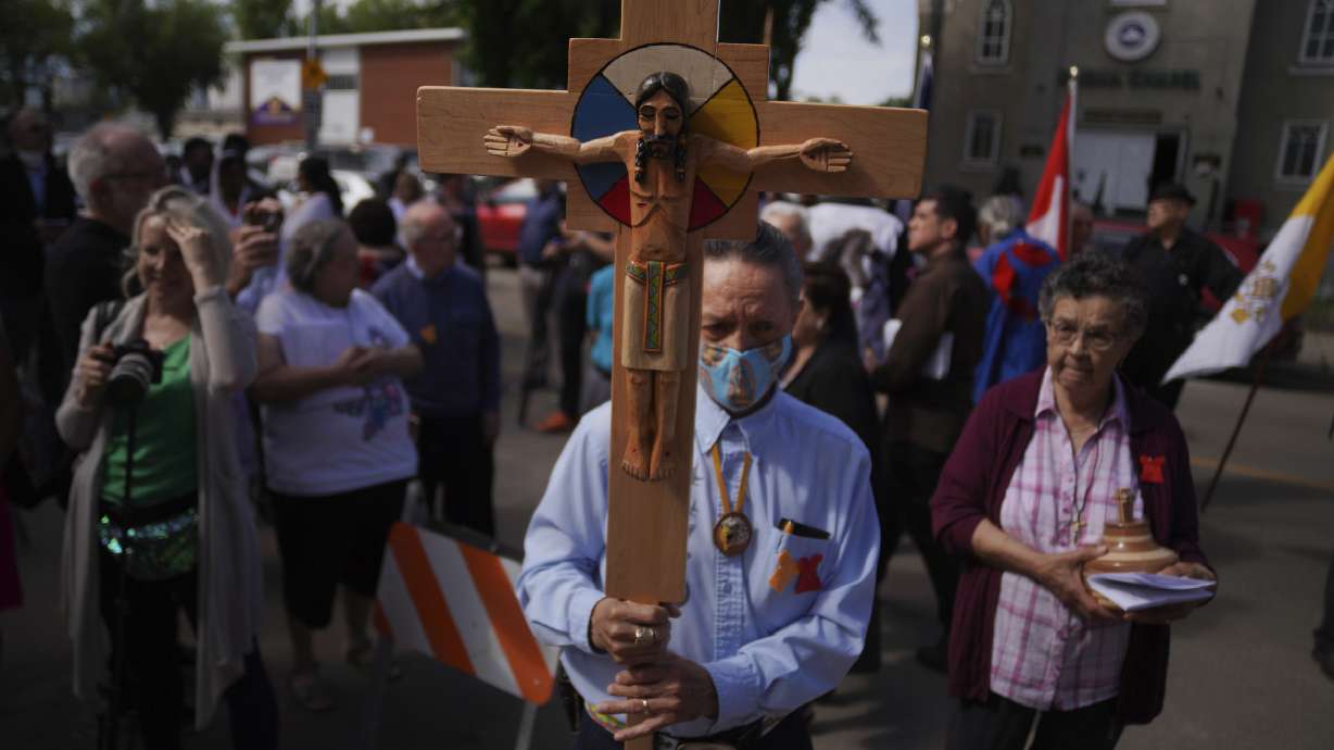 Elmer Waniandy raises the crucifix at Sacred Heart Church of the First Peoples sanctuary on July 17 in Edmonton, Alberta. Pope Francis’ trip to Canada, which begins Sunday, to apologize for the horrors of church-run Indigenous residential schools marks a radical rethink of the Catholic Church’s missionary legacy in the Americas.