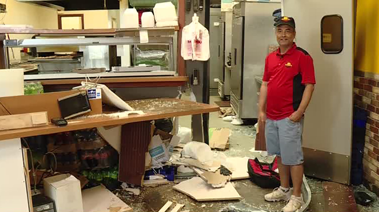 Biplove Timilsina, owner of Big Daddy’s Pizza, talks to KSL Saturday. Damage is shown after a car crashed into the front of the business Friday.