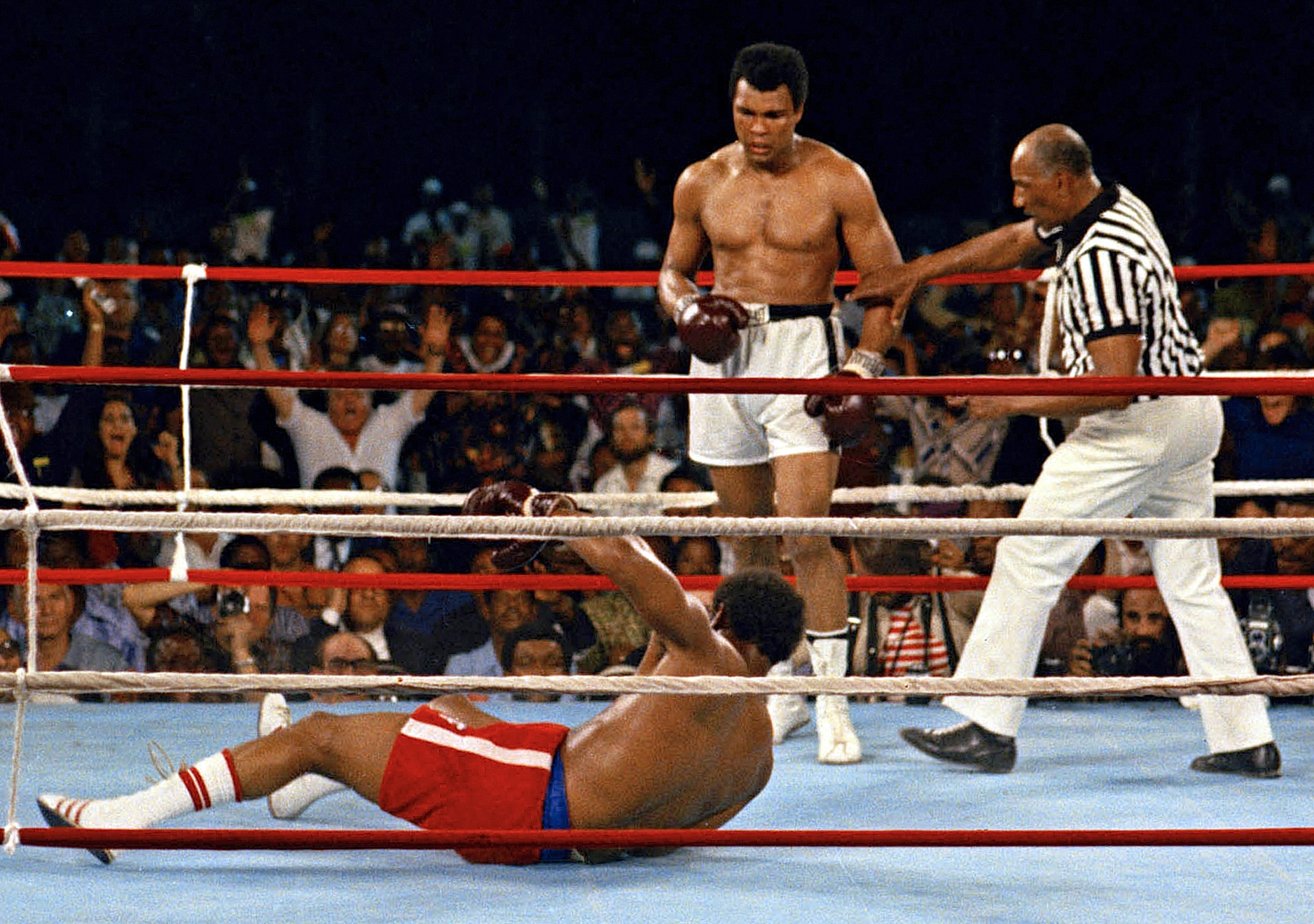 FILE - Referee Zack Clayton, right, steps in after challenger Muhammad Ali, second from right, knocked down defending heavyweight champion George Foreman, bottom, in the eighth round of their championship bout on Oct. 30, 1974, in Kinshasa, Zaire. Ali’s championship belt from the 1974 “Rumble in the Jungle” heavyweight title fight was sold at auction on Sunday, July 24, 2022, for $6.18 million. 