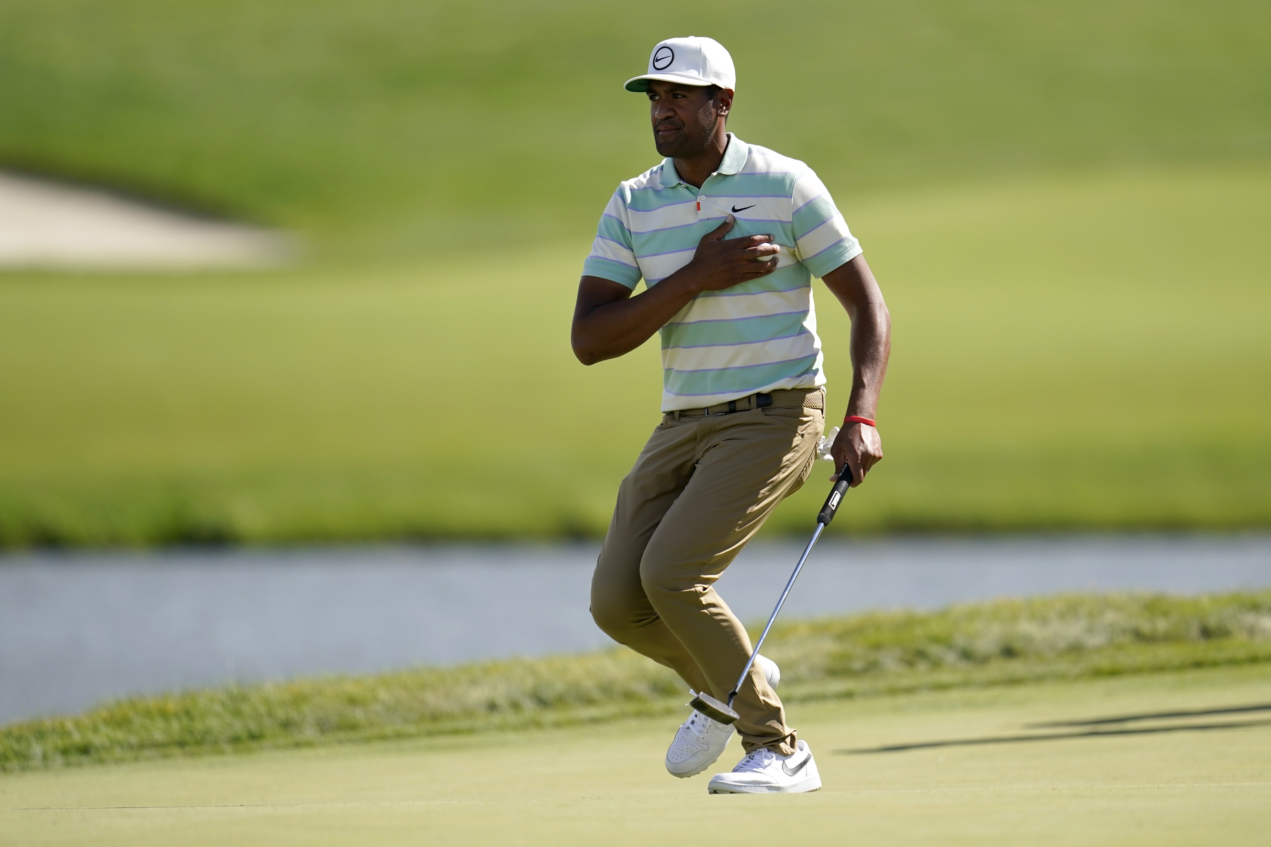 Tony Finau places the ball to his chest and reacts to his putt for par on the 17th green during the final round of the 3M Open golf tournament at the Tournament Players Club in Blaine, Minn., Sunday, July 24, 2022. 