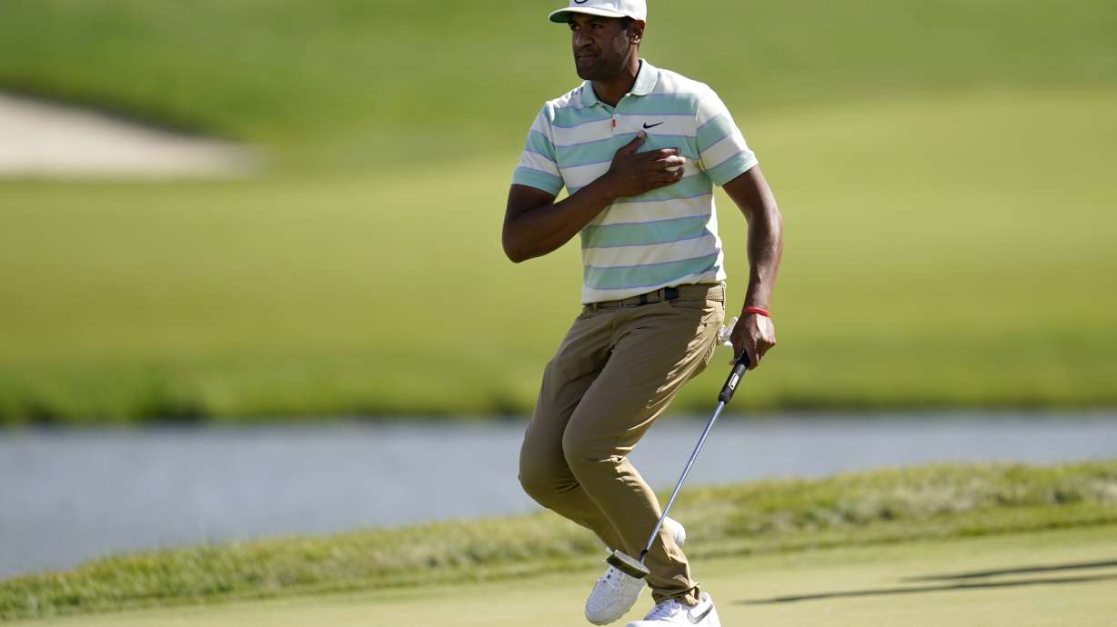 Tony Finau places the ball to his chest and reacts to his putt for par on the 17th green during the final round of the 3M Open golf tournament at the Tournament Players Club in Blaine, Minn., Sunday, July 24, 2022.