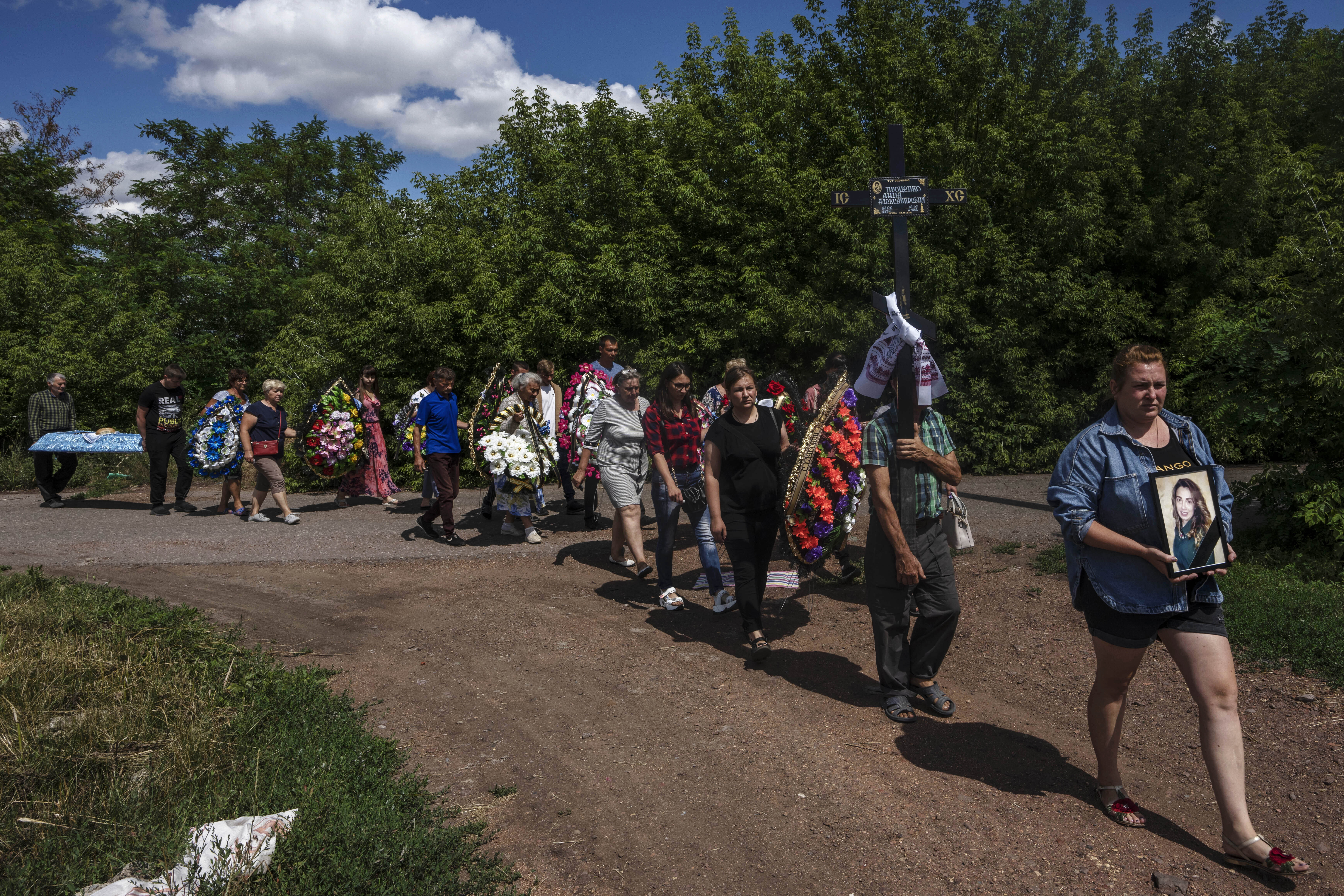 Family and friends of 35-year-old Anna Protsenko, who was killed in a Russian rocket attack, walk to a cemetery for her burial, during her funeral procession, on the outskirts of Pokrovsk, eastern Ukraine, July 18. Protsenko was killed two days after coming home. She had done what authorities wanted, evacuating eastern Ukraine's Donetsk region as Russian forces move closer, but starting a new life elsewhere was uncomfortable and expensive. 