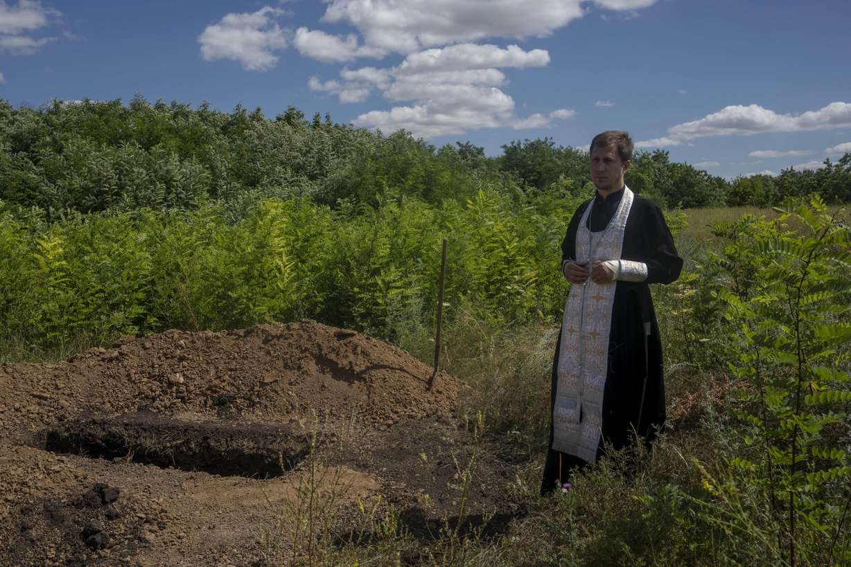 A priest prepares to pray over the lifeless body of 35-year-old Anna Protsenko, who was killed in a Russian rocket attack, before her burial, during her funeral procession, on the outskirts of Pokrovsk, eastern Ukraine, July 18. Protsenko was killed two days after coming home. She had done what authorities wanted, evacuating eastern Ukraine's Donetsk region as Russian forces move closer, but starting a new life elsewhere was uncomfortable and expensive.