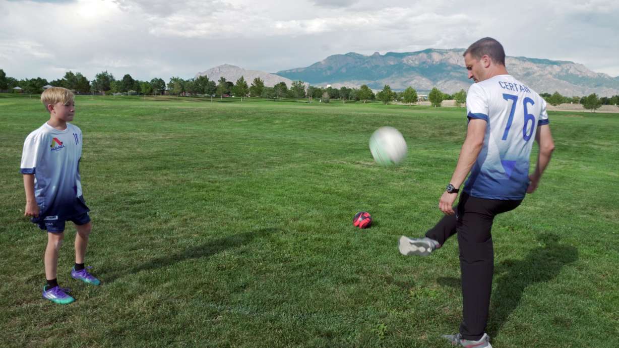 In this photo provided by Vince Trujillo, David Certain, right, plays soccer with his son Nico in Albuquerque, New Mexico, Thursday, July 21, 2022. Certain, a Colombian soccer lover who came to the United States as a political refugee, has united several former professional Colombian soccer players to join him in creating a youth sports education program in New Mexico in July 2022.