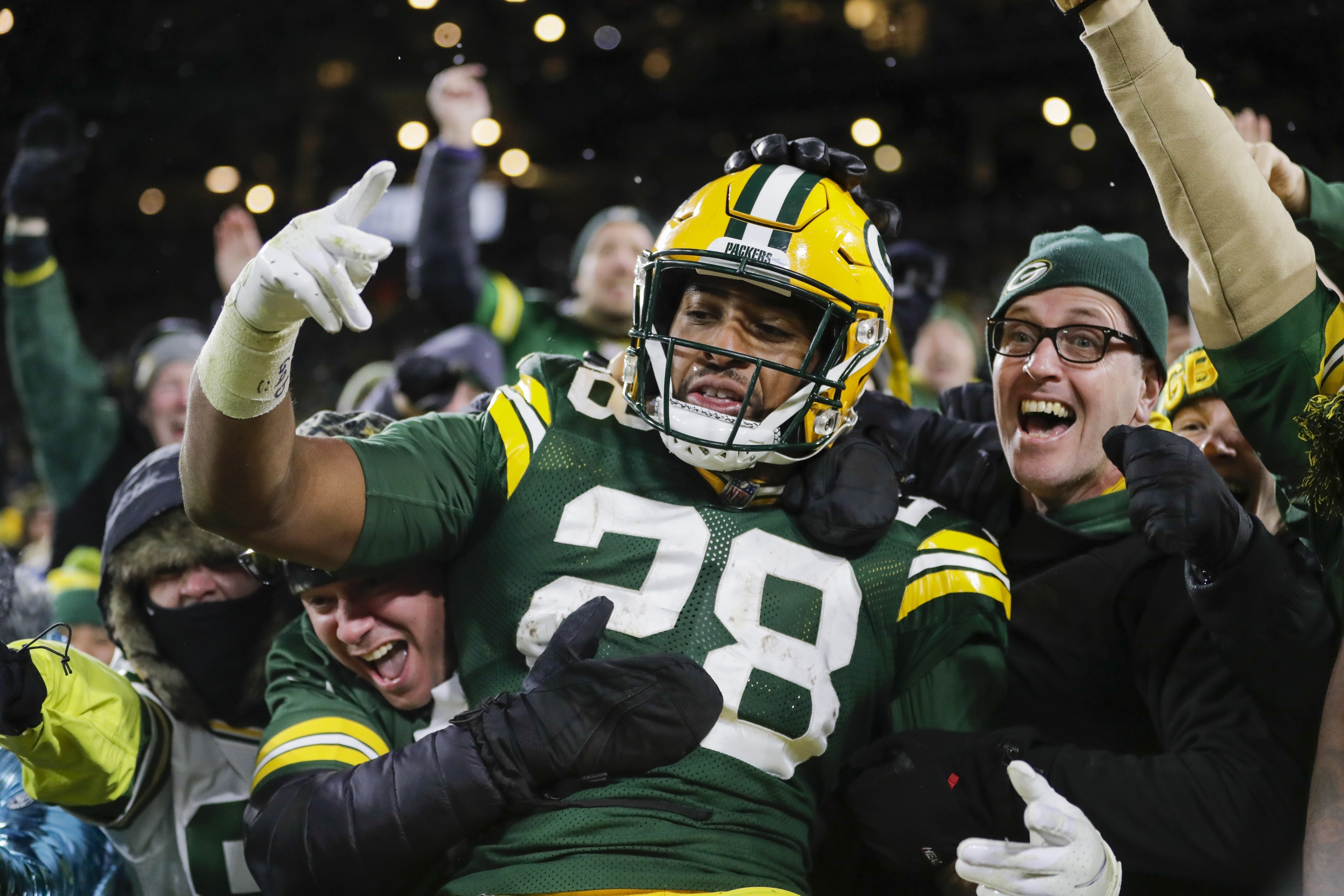 FILE - Green Bay Packers' AJ Dillon celebrates with fans after rushing for a touchdown during the second half of an NFL football game against the Seattle Seahawks, Sunday, Nov. 14, 2021, in Green Bay, Wis. Green Bay police say their internal affairs department is conducting a review after a video on social media showed an officer grabbing Packers running back A.J. Dillon during a Saturday night, July 23, 2022, soccer match at Lambeau Field. 