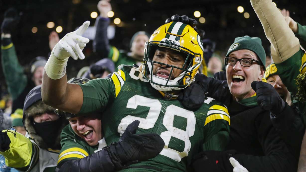 FILE - Green Bay Packers' AJ Dillon celebrates with fans after rushing for a touchdown during the second half of an NFL football game against the Seattle Seahawks, Sunday, Nov. 14, 2021, in Green Bay, Wis. Green Bay police say their internal affairs department is conducting a review after a video on social media showed an officer grabbing Packers running back A.J. Dillon during a Saturday night, July 23, 2022, soccer match at Lambeau Field.