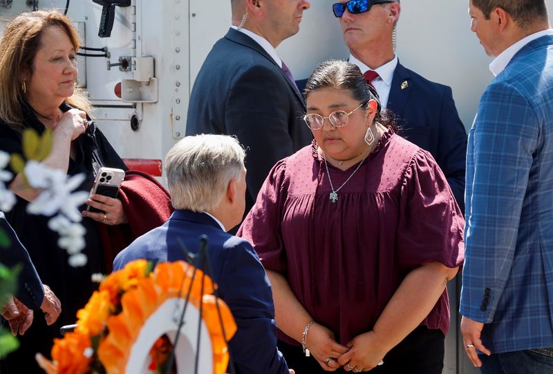 Texas Gov. Greg Abbott speaks with Mandy Gutierrez, principal at Robb Elementary School, where a gunman killed 19 children and two teachers, in Uvalde, Texas, May 29.