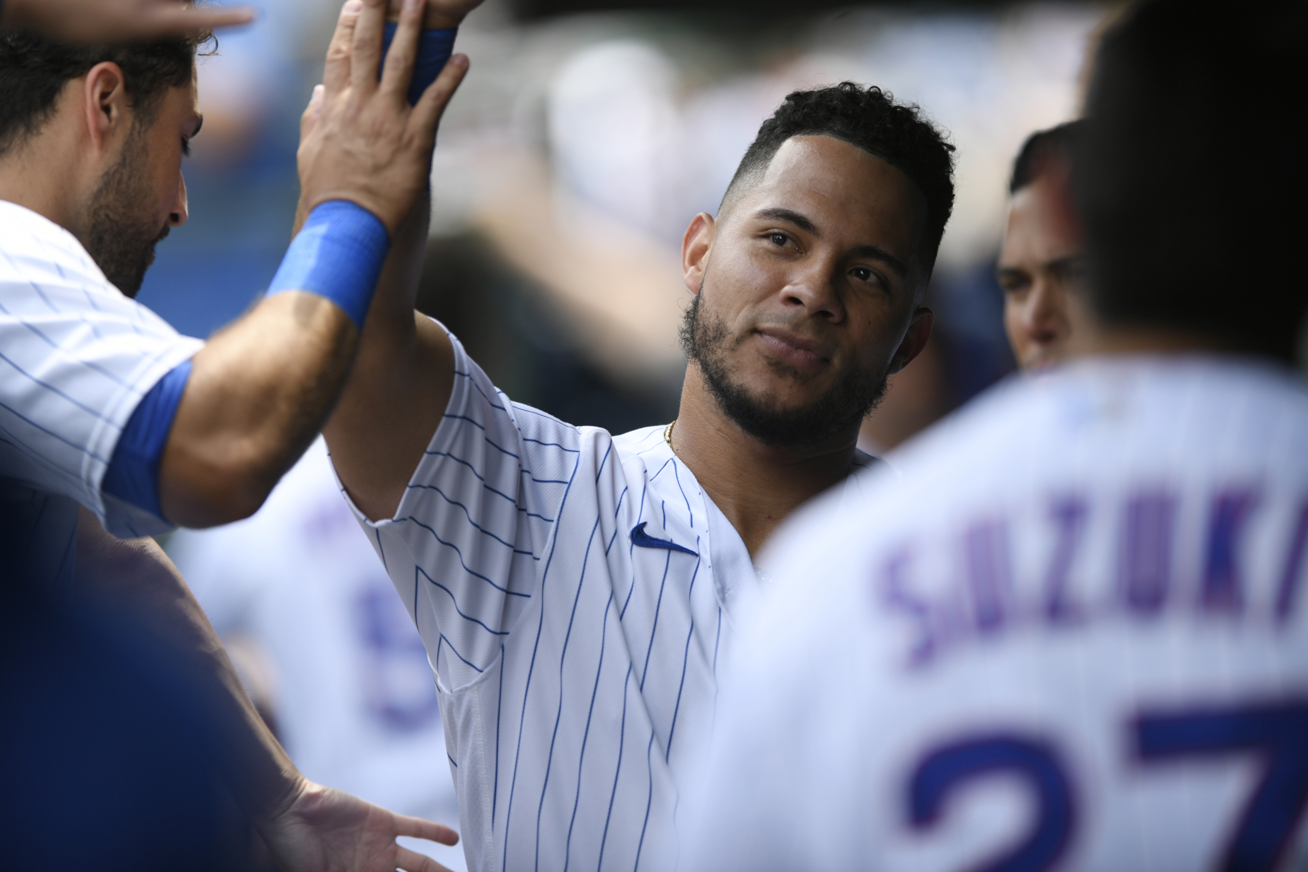 Chicago Cubs' Willson Contreras celebrates with teammates in the dugout after scoring on a two RBI double hit by Ian Happ during the first inning of a baseball game against the Pittsburgh Pirates Tuesday, July 26, 2022, in Chicago. 