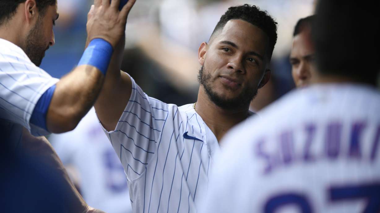 Chicago Cubs' Willson Contreras celebrates with teammates in the dugout after scoring on a two RBI double hit by Ian Happ during the first inning of a baseball game against the Pittsburgh Pirates Tuesday, July 26, 2022, in Chicago.
