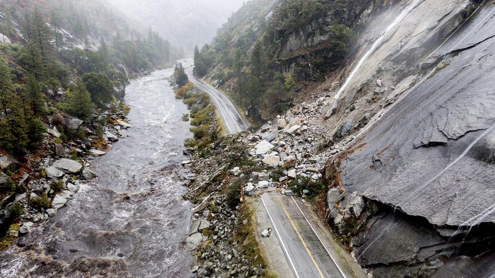 Rocks and vegetation cover Highway 70 following a landslide in the Dixie Fire zone on Oct. 24, 2021, in Plumas County, Calif. Heavy rains blanketing Northern California created slide and flood hazards in land scorched during last summer's wildfires. A sizeable number continue to dismiss the scientific consensus that human activity is to blame.