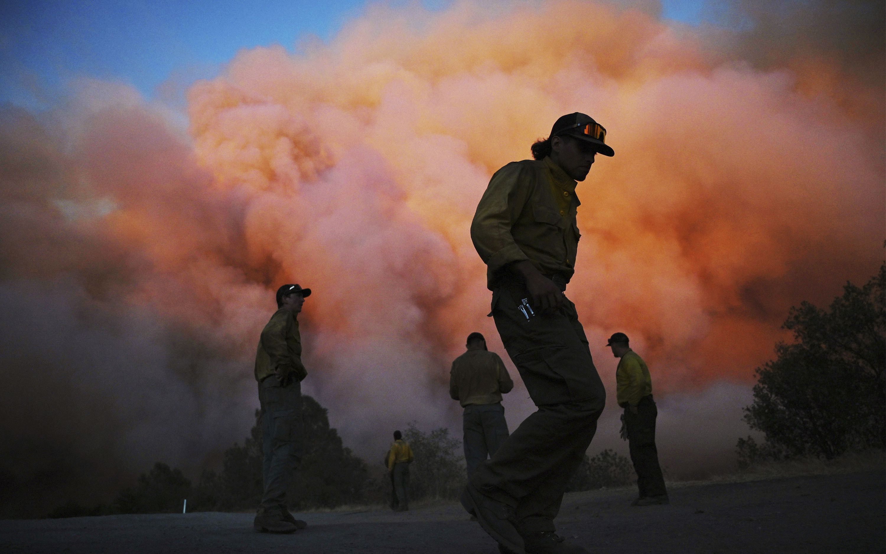 U.S. Forest firefighters watch a wildfire called the Oak Fire burn east of Midpines in Mariposa County, Calif., July 22. Wildfires fed by windy and hot conditions have grown dramatically in Idaho, California and Montana, forcing evacuation orders for over 100 homes.