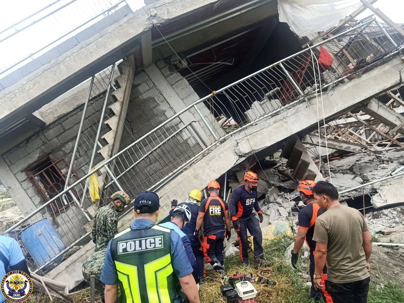 Emergency crews conduct rescue operations outside a building that collapsed during the earthquake, in La Trinidad, Benguet, Philippines, Wednesday.