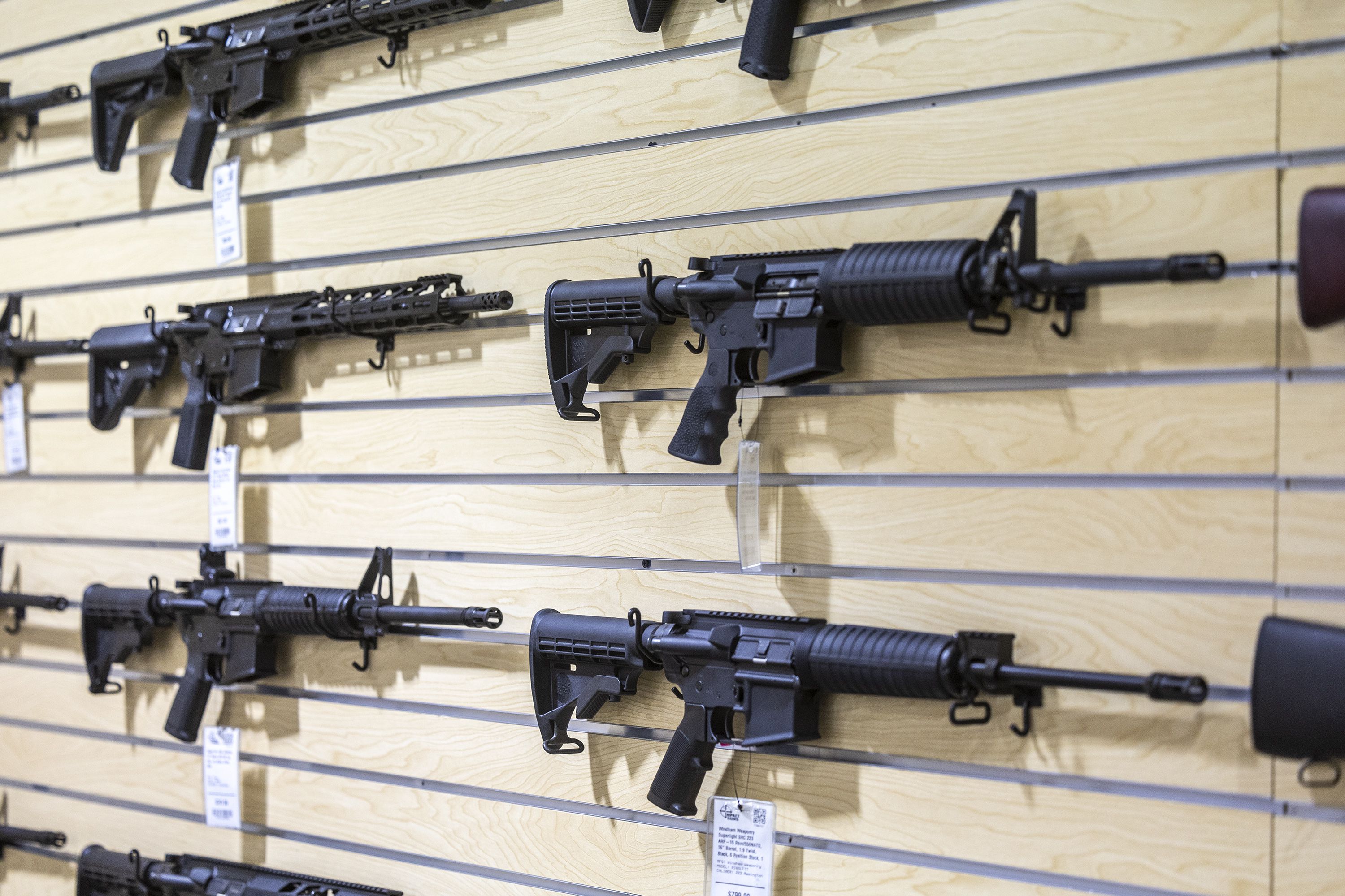 AR-15 rifles are displayed on a wall at Impact Guns in South Salt Lake on July 6. Sales of AR-15 style guns bring in big revenue for manufacturers, according to a report.