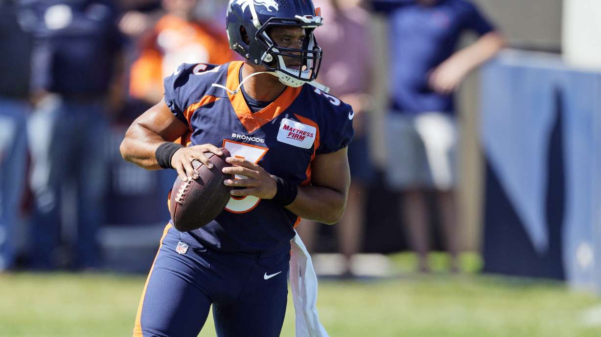 Denver Broncos quarterback Russell Wilson takes part in drills during the opening session of the NFL football team's training camp Wednesday, July 27, 2022, in Centennial, Colo.