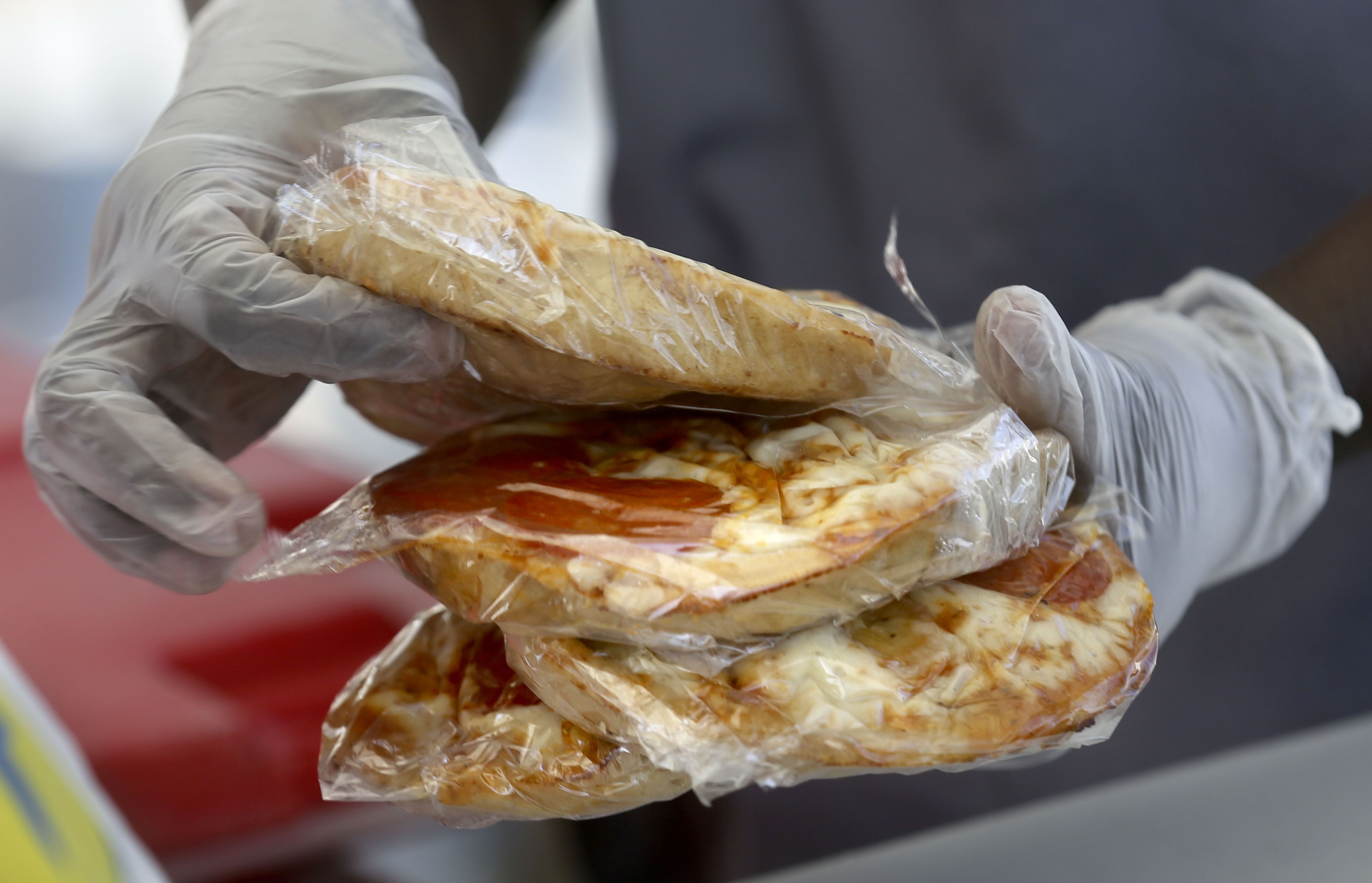 Nutrition technician Besie Sabit puts slices of pizza into bagged lunches outside of Edison Elementary School in Salt Lake City on Sept. 28, 2020. Utah Attorney General Sean D. Reyes on Wednesday joined 22 other attorneys general in a lawsuit against the Biden Administration for threatening to withhold nutritional assistance for schools that don't follow new sex discrimination programs.