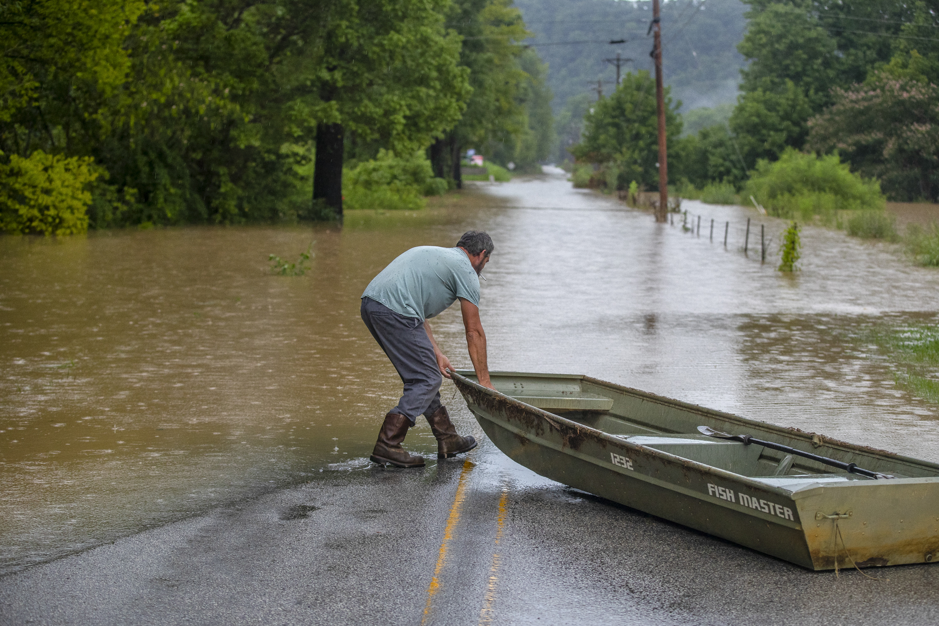 A man prepares to launch a boat near flooded Wolverine Road in Breathitt County, Ky., on Thursday.