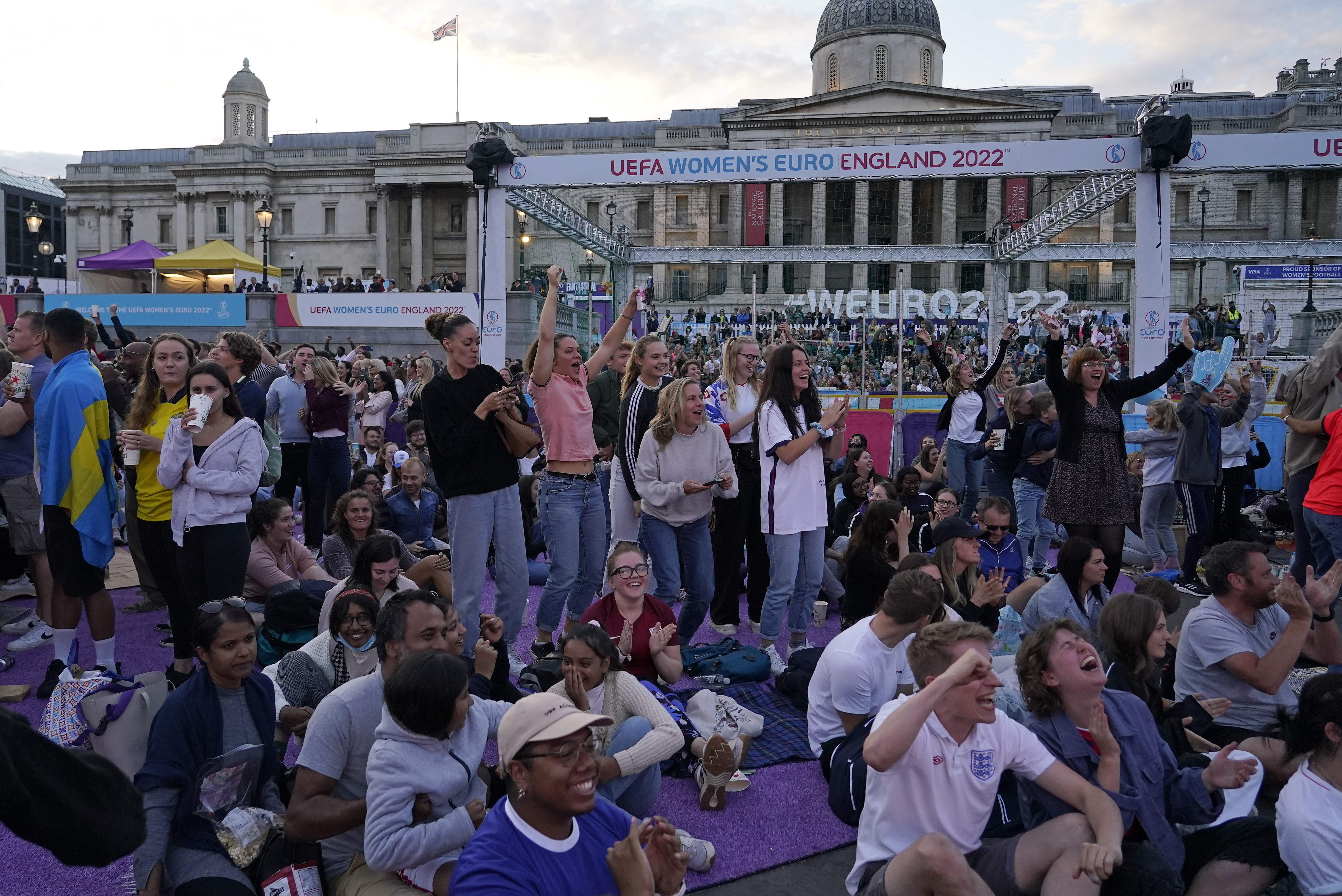 FILE - England supporters celebrate after Beth Mead scored the opening goal as they watch a live screening of the Women's Euro 2022 semifinal soccer match between England and Sweden at the fan area in Trafalgar Square in London, England, Tuesday, July 26, 2022. The march to Sunday's final against Germany has energized people throughout England, with the team's pinpoint passing and flashy goals attracting record crowds, burgeoning TV ratings and adoring coverage. The Lionesses, as the team is known, have been a welcome distraction from the political turmoil and cost-of-living crisis that dominate the headlines. 