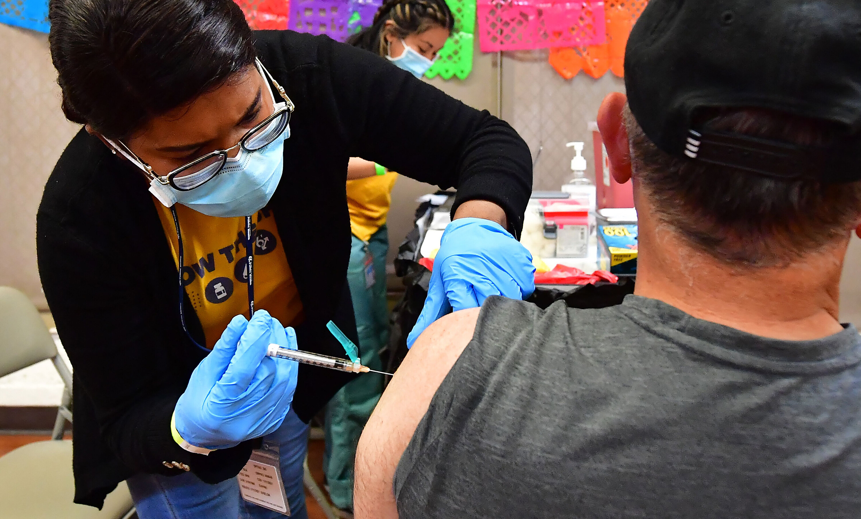 Registered Nurse Mariam Salaam administers the Pfizer booster shot at a COVID vaccination and testing site in Los Angeles on May 5. Moderna and Pfizer booster shots updated to target Omicron subvariants could be available in early fall.