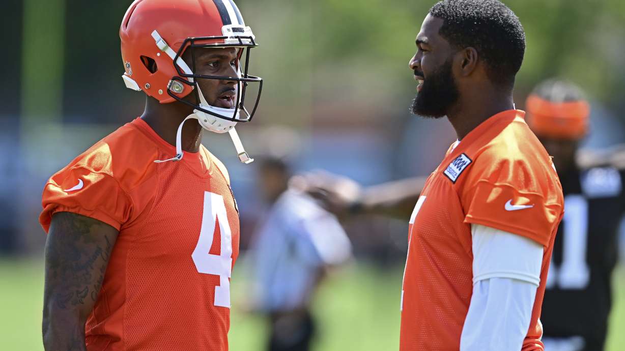 Cleveland Browns quarterbacks Deshaun Watson, left, and Jacoby Brissett talk before an NFL football practice in Berea, Ohio, Saturday, July 30, 2022.