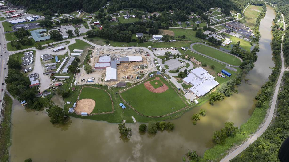 In this aerial image, the river is still high around the homes in Breathitt County, Ky., on Saturday. Recovery has begun in many of the narrow hollers after historic rains flooded many areas of Eastern Kentucky killing more at least two dozen people. A layer of mud from the retreating waters covers many cars and homes.